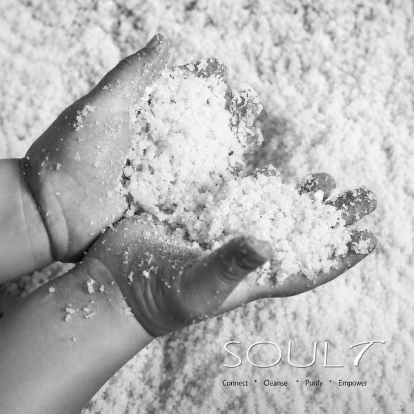 A pair of hands resting in a bowl of SOULt water