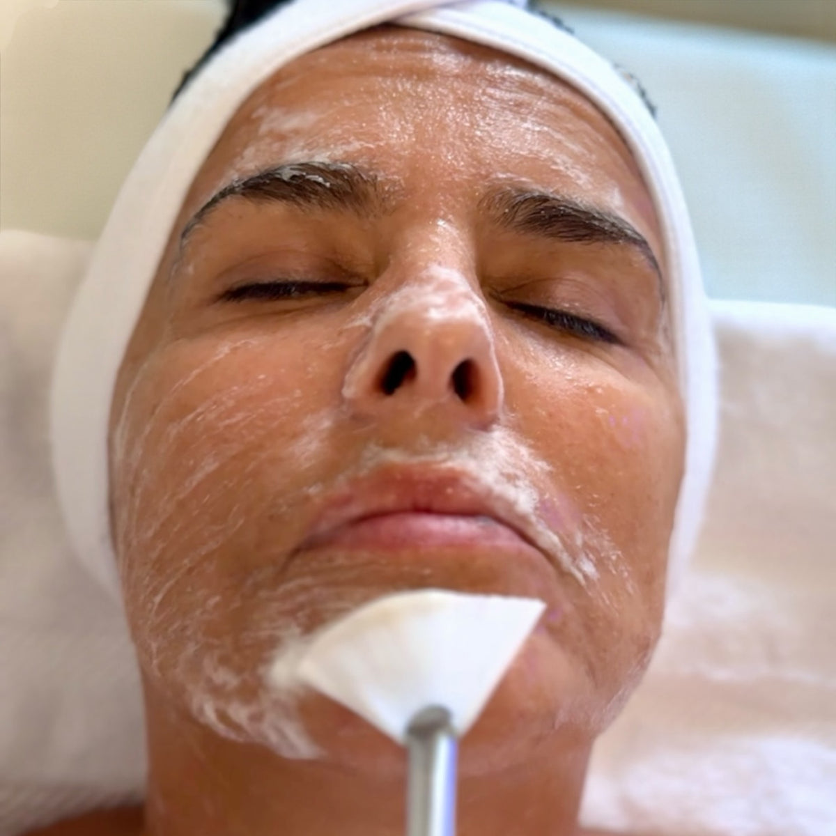 CleanSer being applied with a fan brush during a facial treatment
